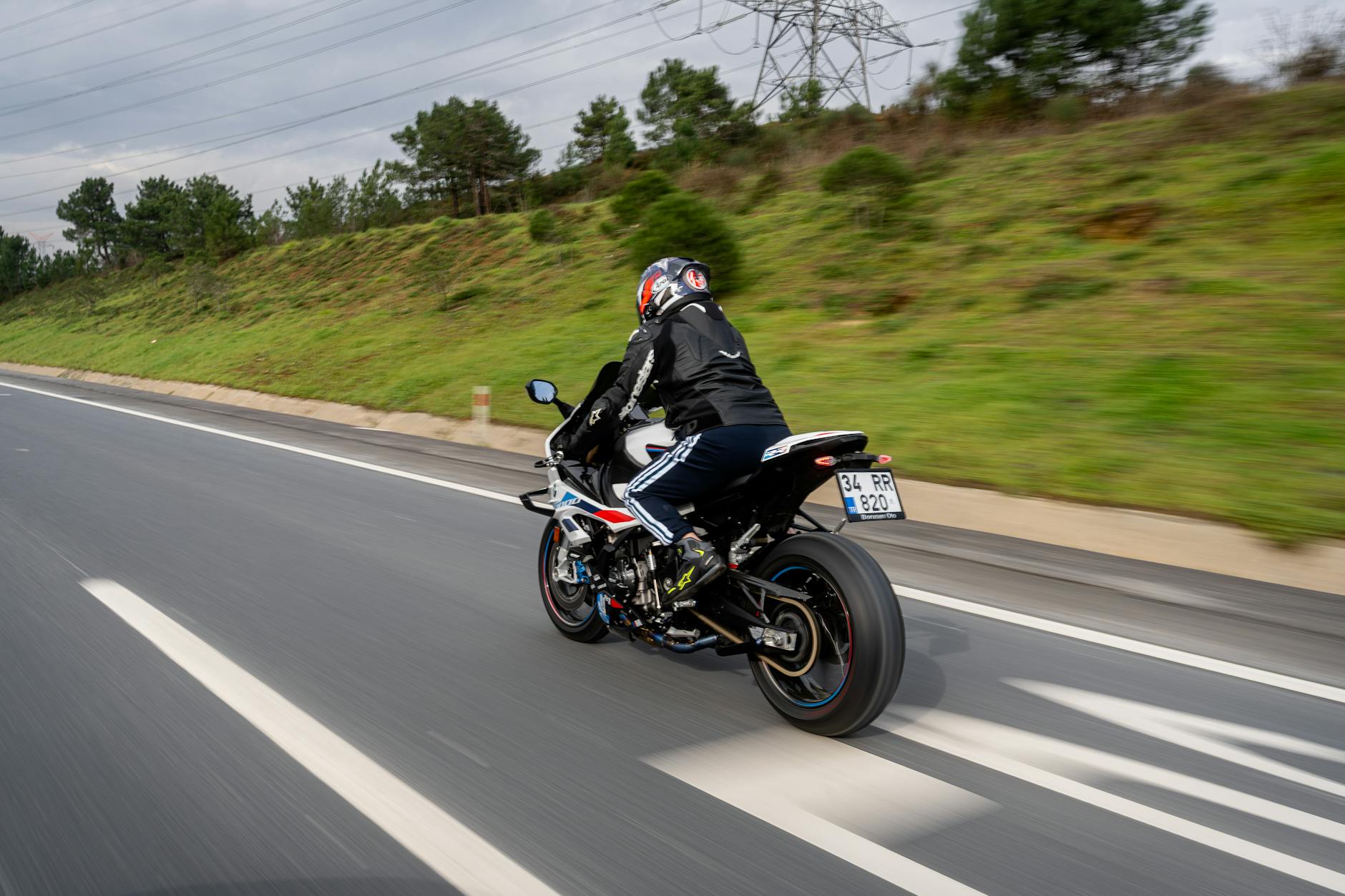 Person riding a motorcycle on a highway, showcasing speed and adventure.
