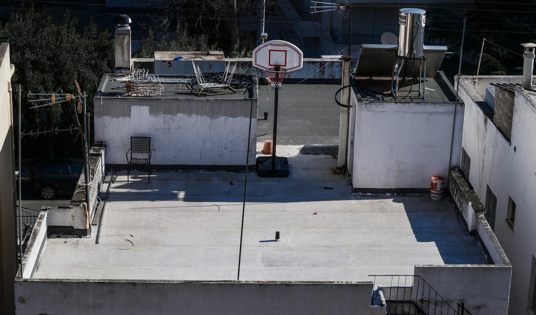 Rooftop basketball hoop on a concrete surface in Athens, Greece.