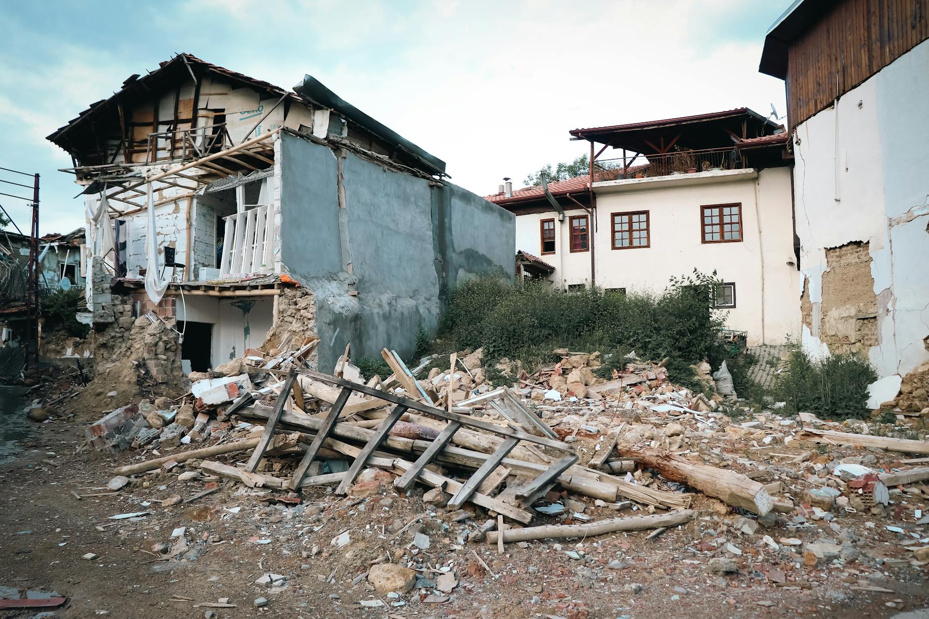 A village destroyed by an earthquake, showcasing damaged buildings and debris.