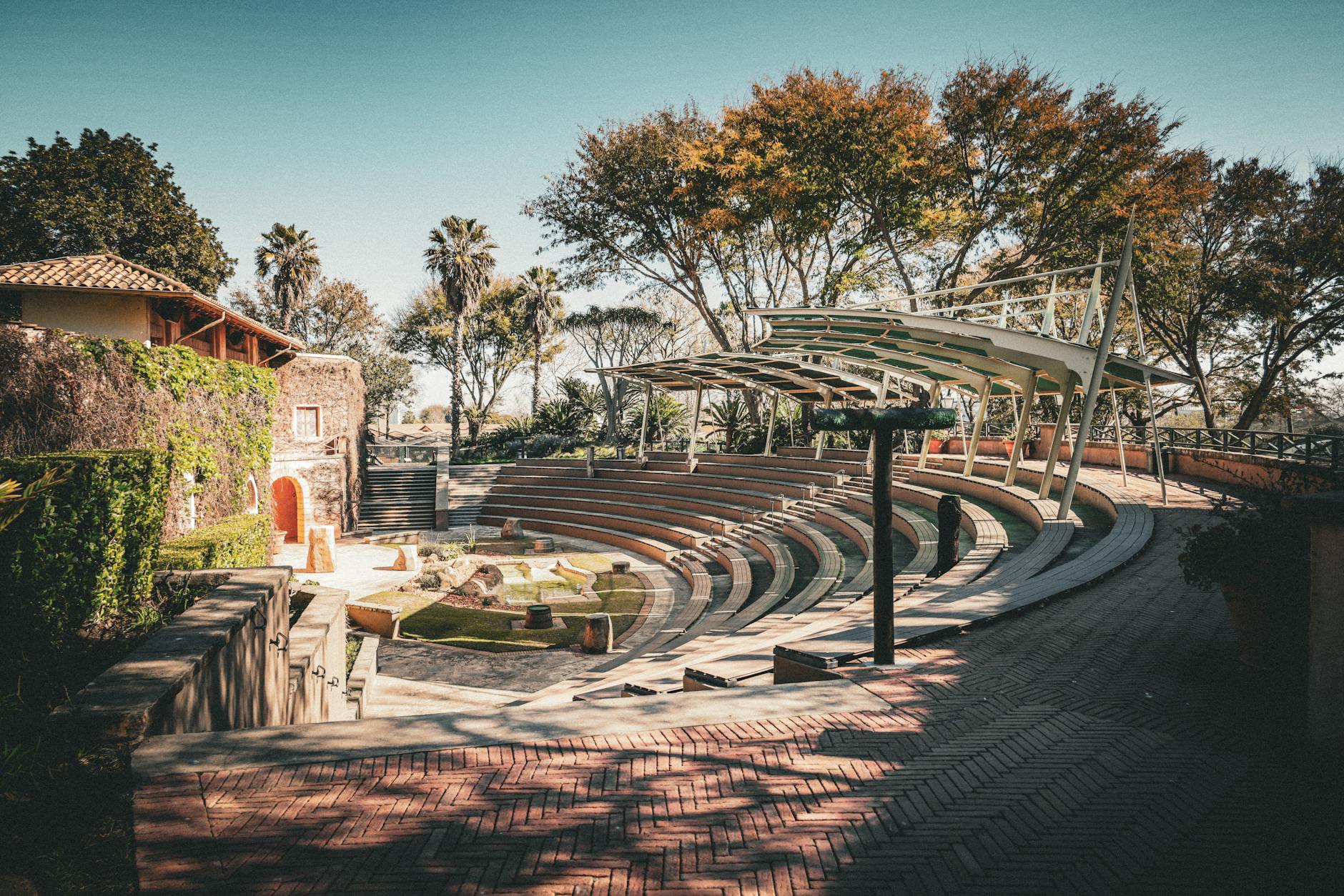 Beautiful outdoor amphitheater with curved seating and leafy backdrop, perfect for events.