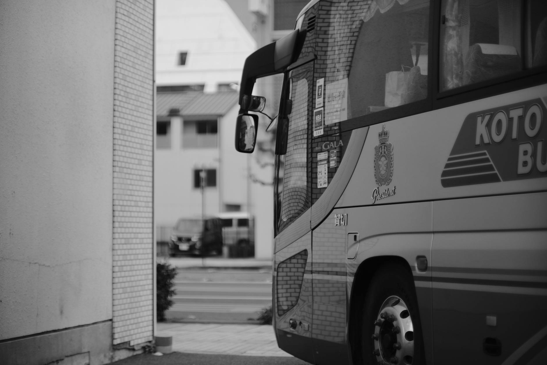 Monochromatic photo of a city bus on urban street, offering a classic cityscape view.