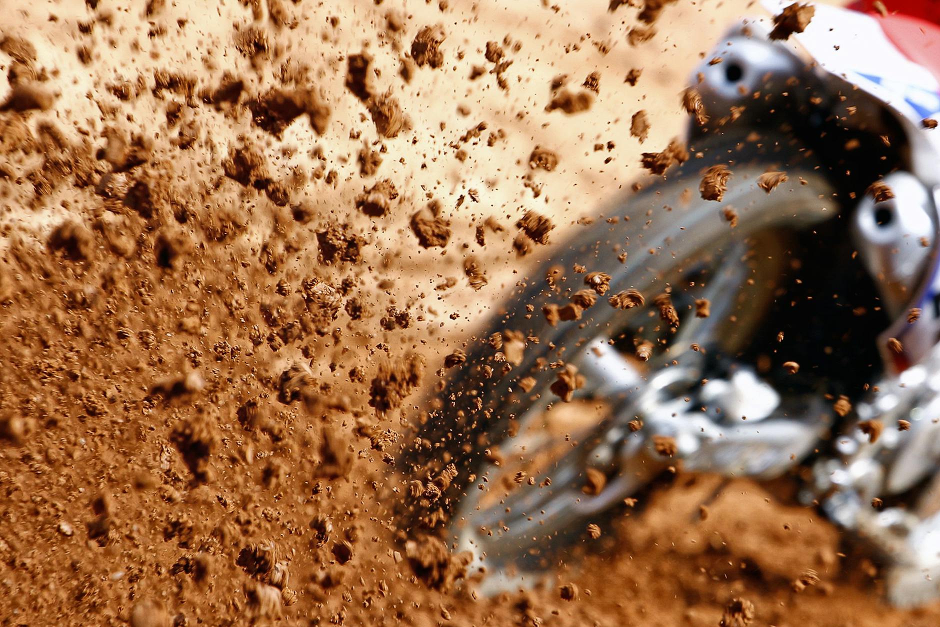 Close-up of a motocross bike kicking up dirt during an offroad race.